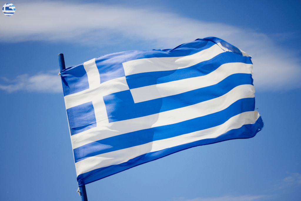 Greek Flag waving in the wind with sky and clouds behind it